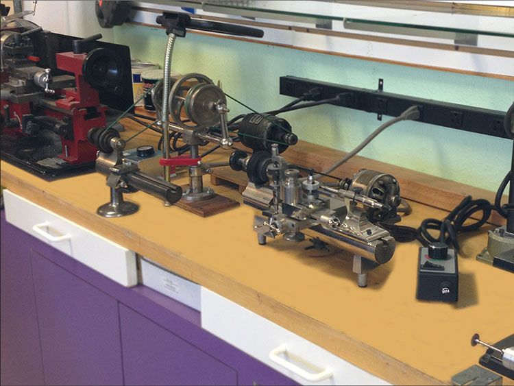 Watchmaker's lathes and attachments lined up on a workbench